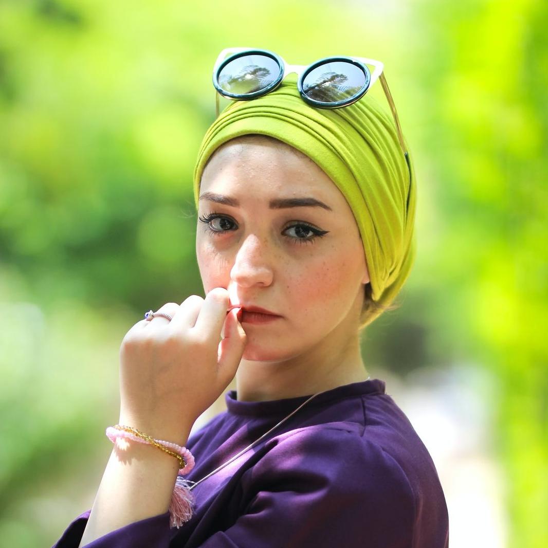woman wearing purple long-sleeved top holding her lips during daytime